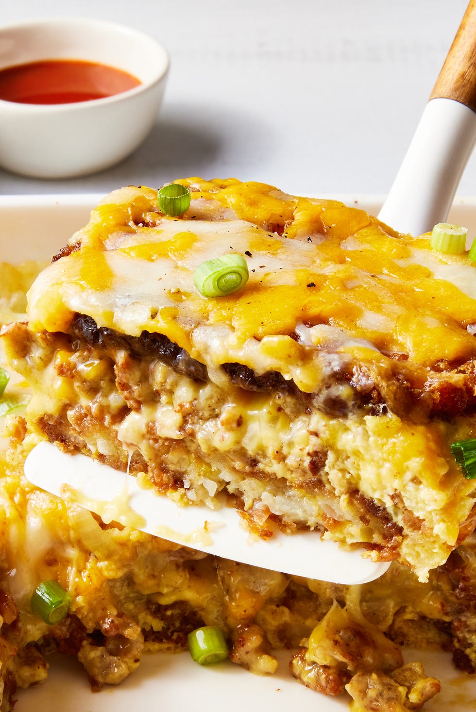 layered hashbrowns, eggs, and sausage topped with cheese and baked in a casserole dish