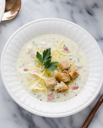 chicken cordon bleu soup in white bowl marble background