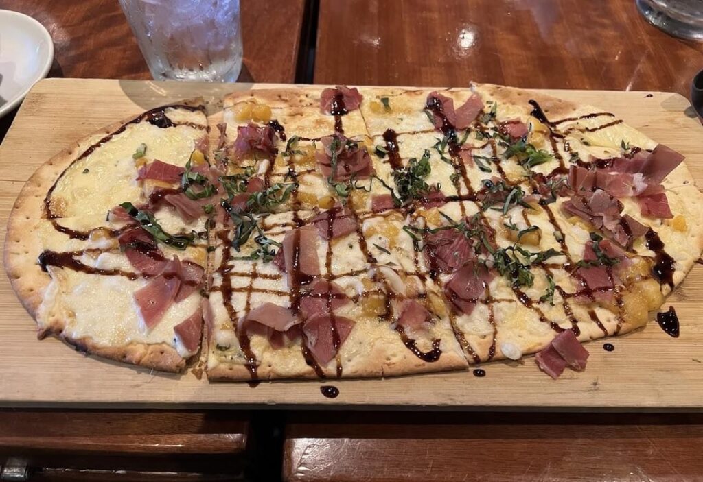 How many cals in a piece of this peach Brie flatbread WITHOUT the prosciutto and a piece of this veggie sushi?