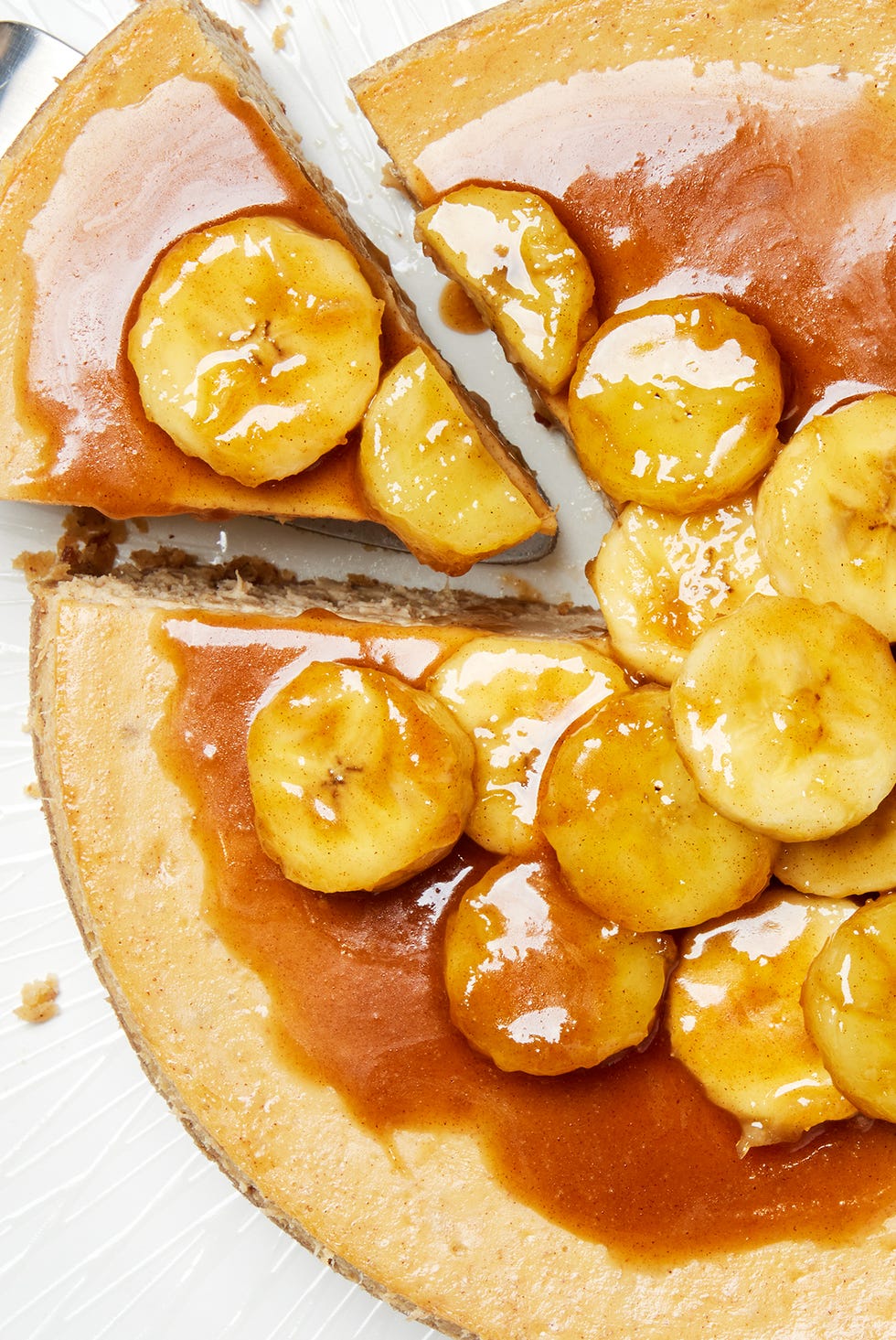 bananas foster cheesecake topped with caramel sauce and sliced bananas