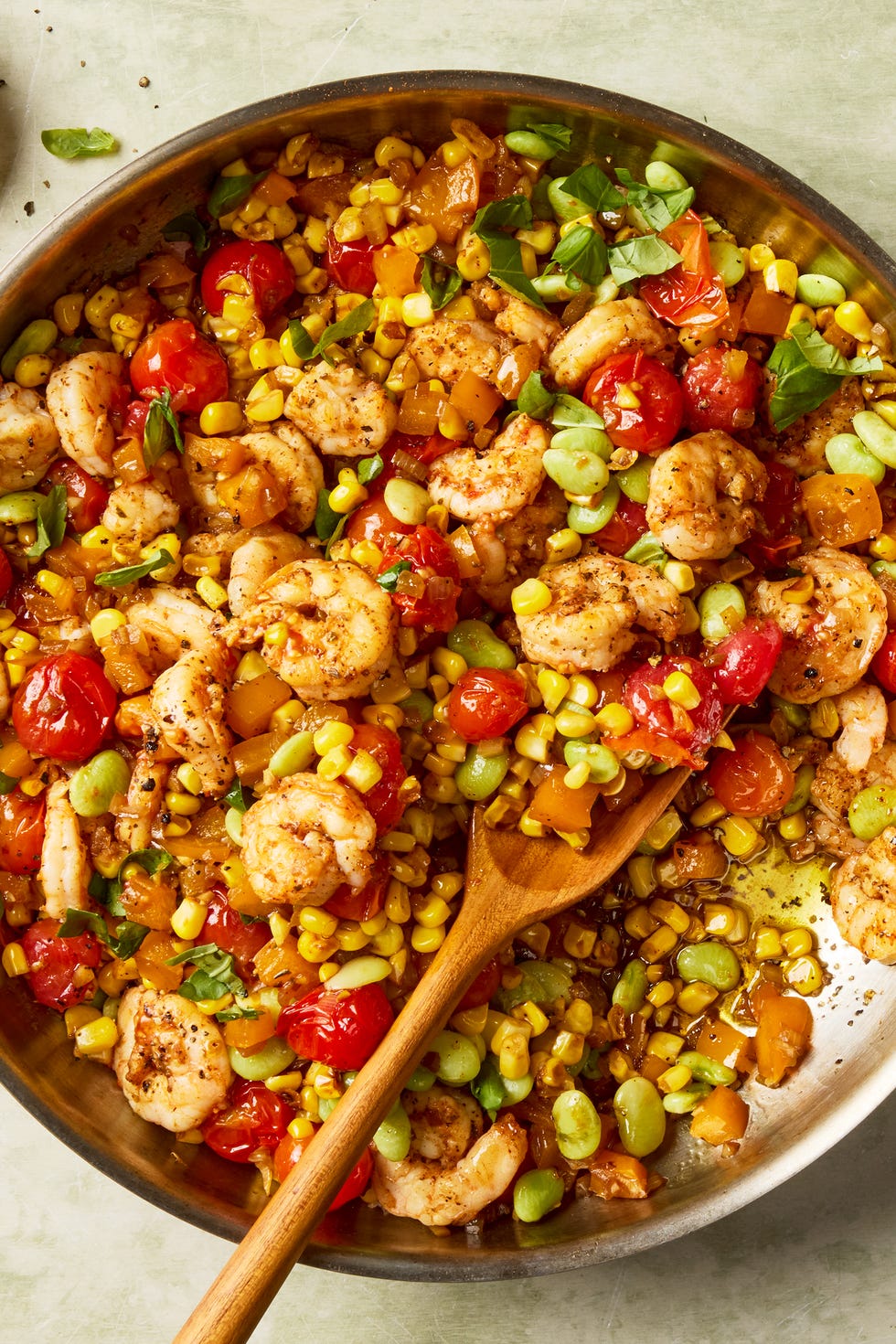 blistered tomatoes and charred corn tossed with onion, bell pepper, lima beans, and seared cajun spiced shrimp then topped with a flurry of torn basil