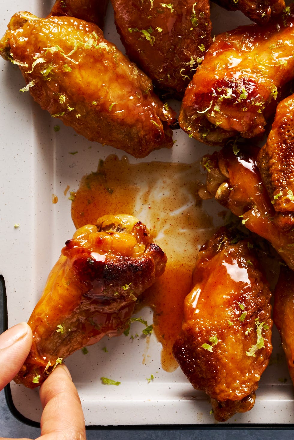 coconut lime chicken wings on a tray topped with lime zest