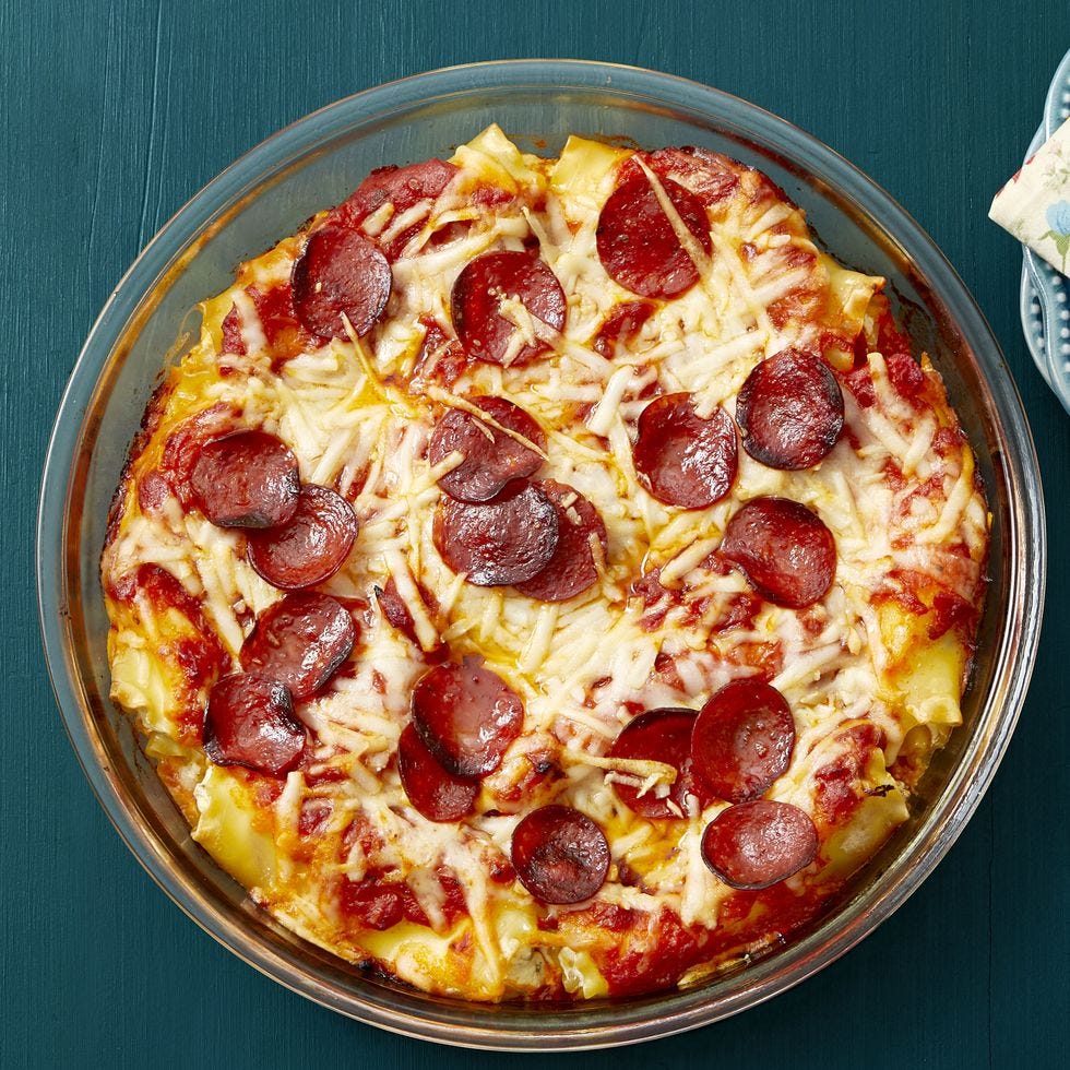 pepperoni pizza lasagna roll ups in glass dish on teal background