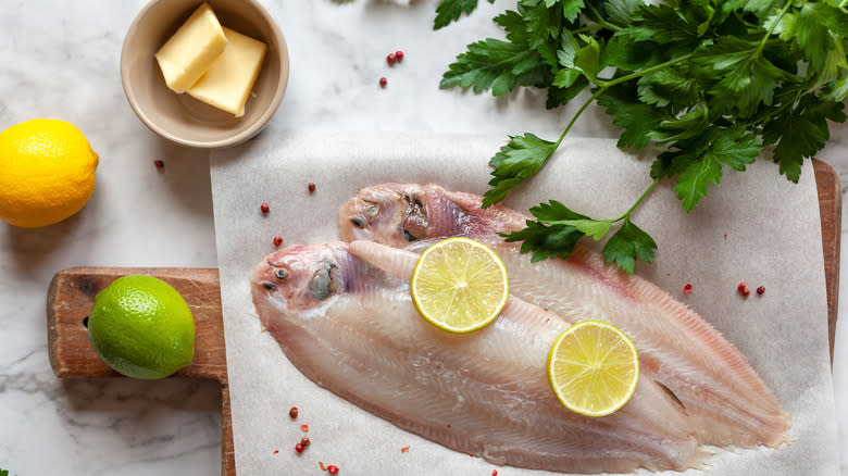 Ingredients for sole meunière, fish, butter, lemon, and parsley, before it it coooked.
