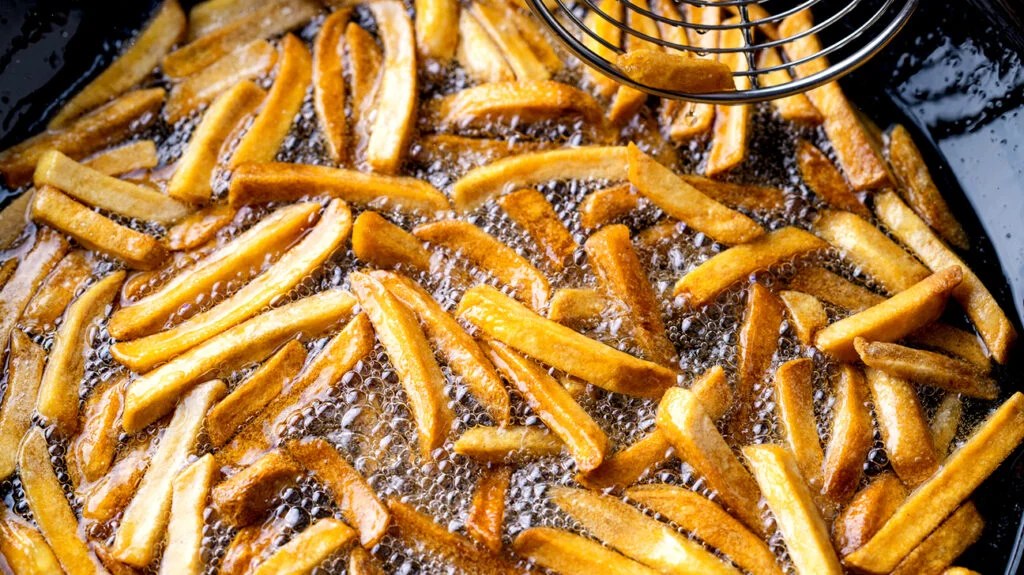 French fries being fried in a pan of hot oil