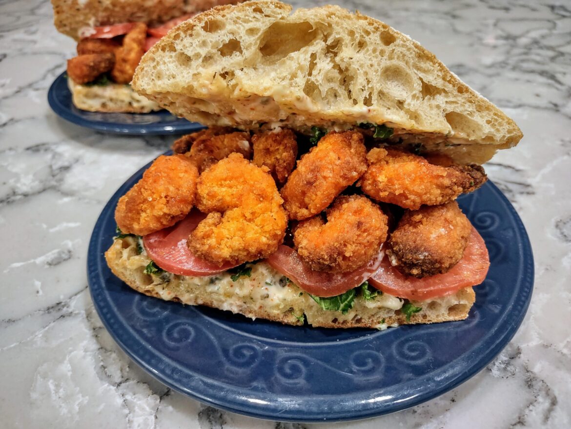 Homemade Shrimp Po' Boy Sandwich (Fried Shrimp, Kale, Tomato, and Remoulade Sauce on Ciabatta Bread).