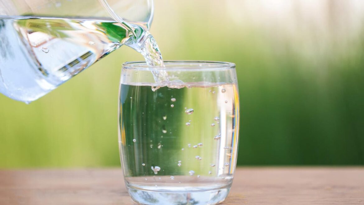 We Asked a Registered Dietitian How Much Water You Actually Need pouring a glass of water