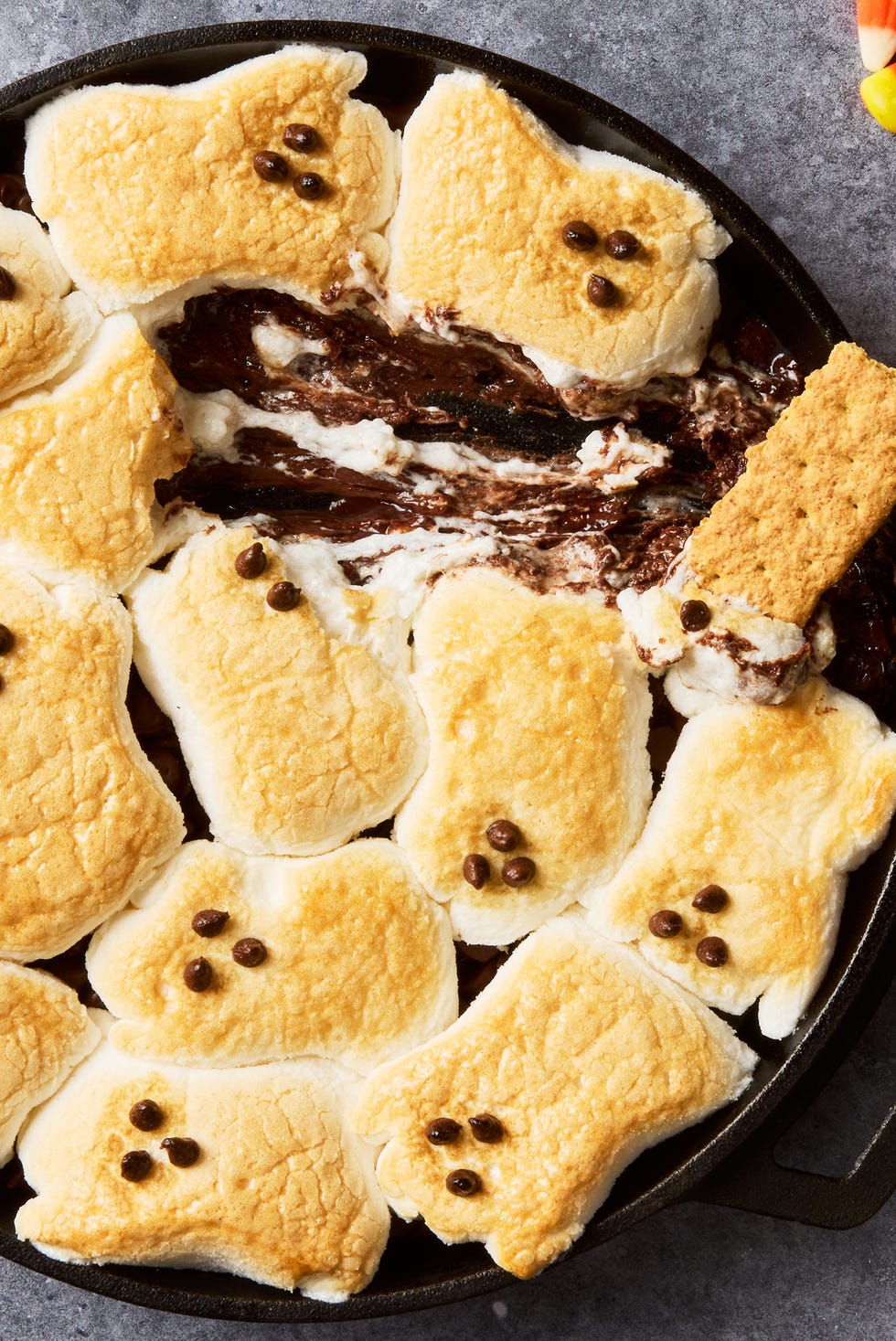 s'mores dip with ghost marshmallows on top served with graham crackers