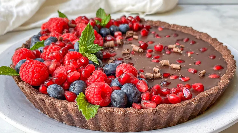 Chocolate tart with fruit and mint leaves