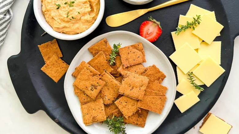 Board of crackers, cheese, dip, and strawberries