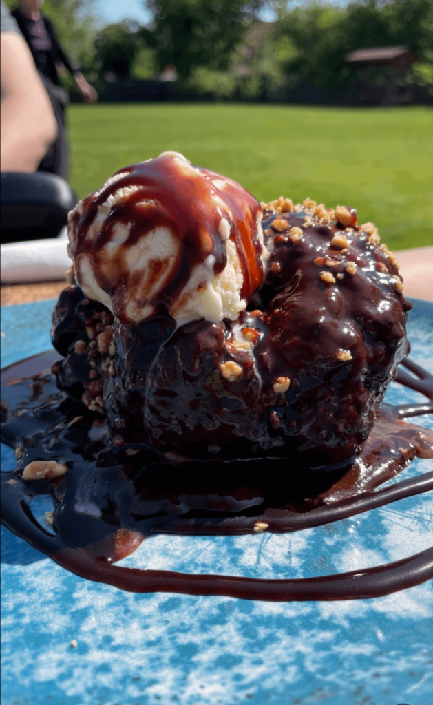 Doughnut covered in chocolate and vanilla ice cream!