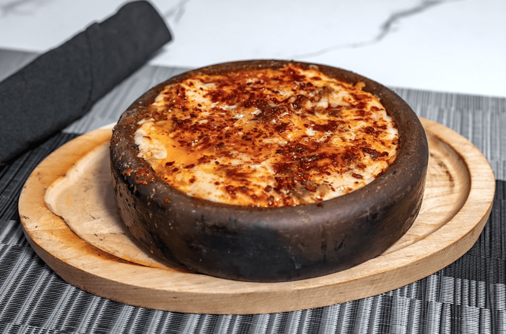 A dish over crisp oven baked hummus in a brown dish. 