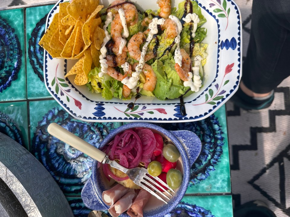 a plate of shrimp salad next to a plate of tortilla chips