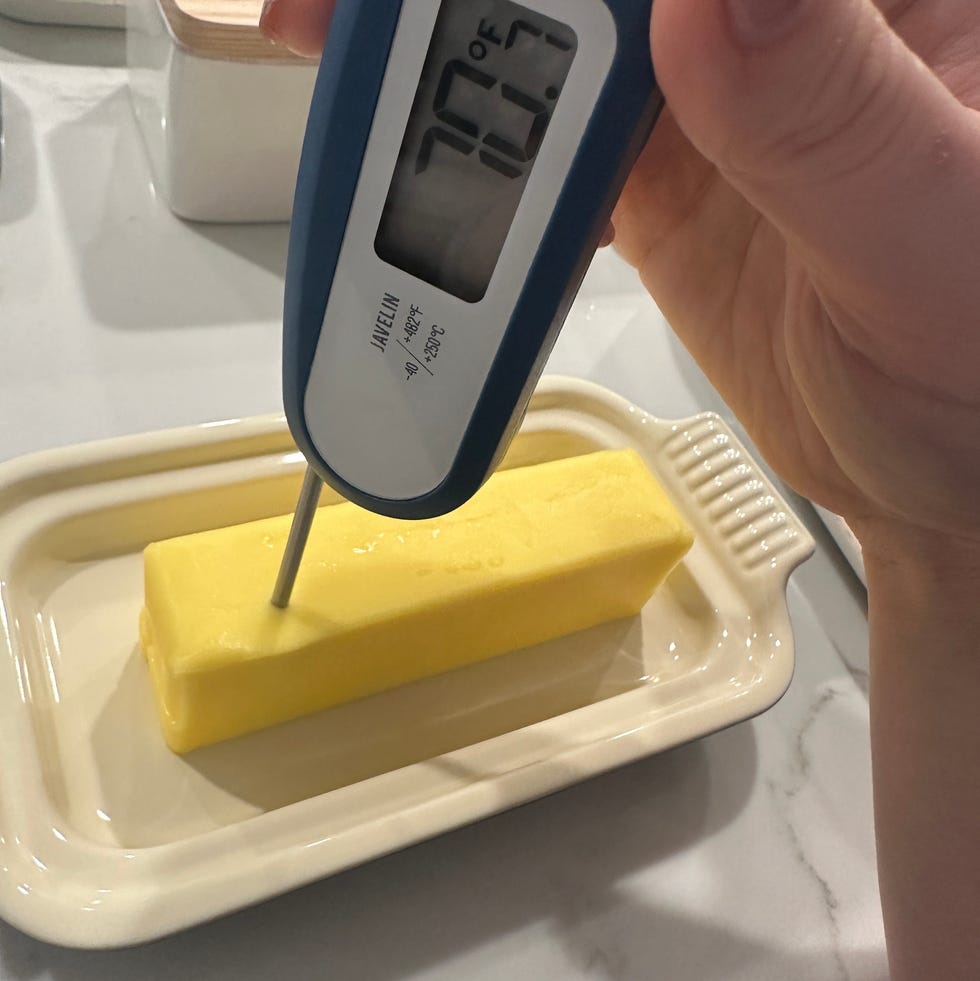 thermometer measuring the temperature of a butter stick on a plate