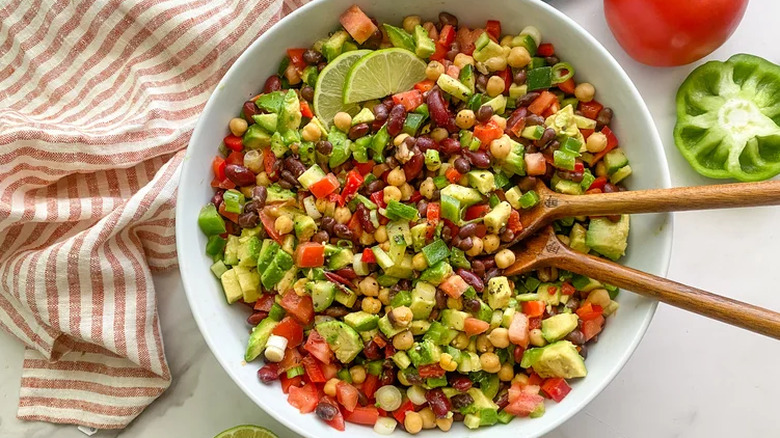 Bowl of three bean salad with two wooden serving spoons