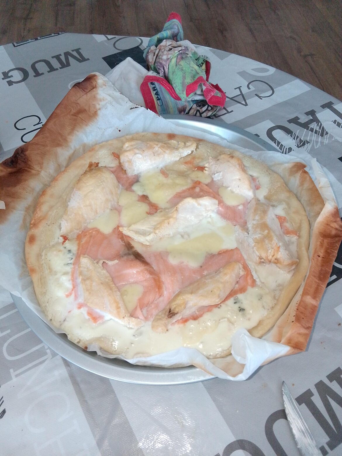 A beautiful chicken, salmon, sour cream pizza, topped with blue and cantal cheese
