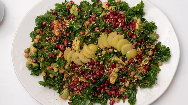 Chickpea and kale salad with pomegranate seeds on plate