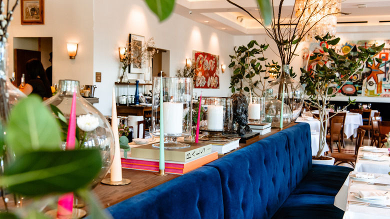 The maximalist interior of Le Bilboquet, featuring a royal blue booth and colorful decor