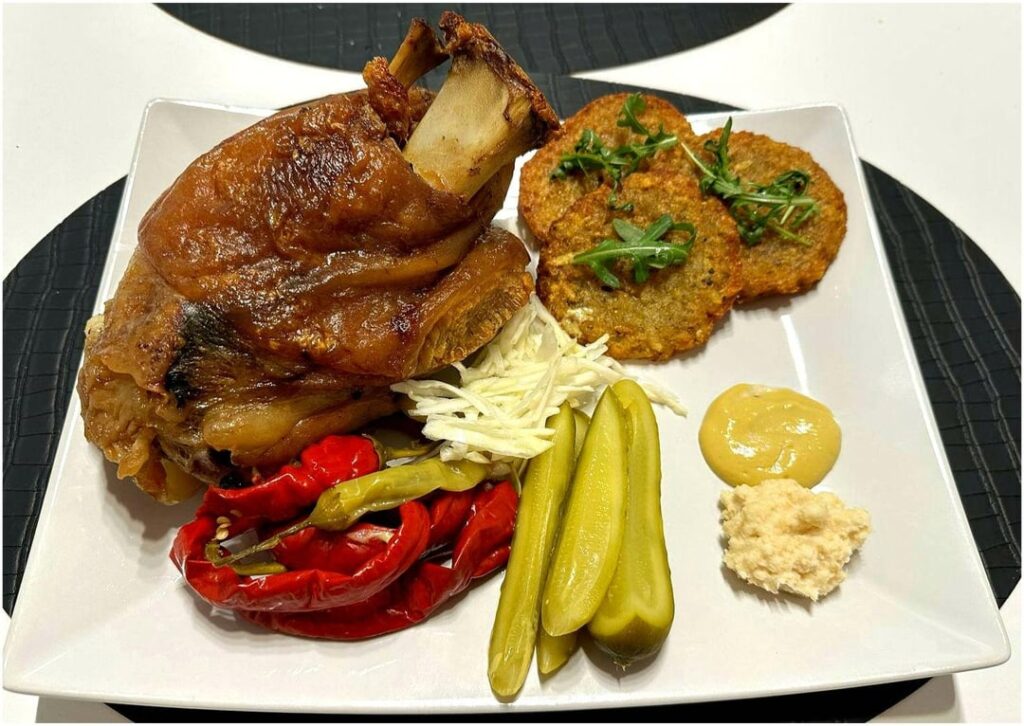 Grilled pork knuckle, potato pancakes, mustard, horseradish and vegetables. Desserts with cream, strawberries, nuts.