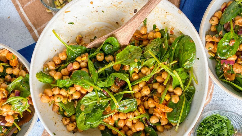 Chickpea salad garnished with spinach in large bowl