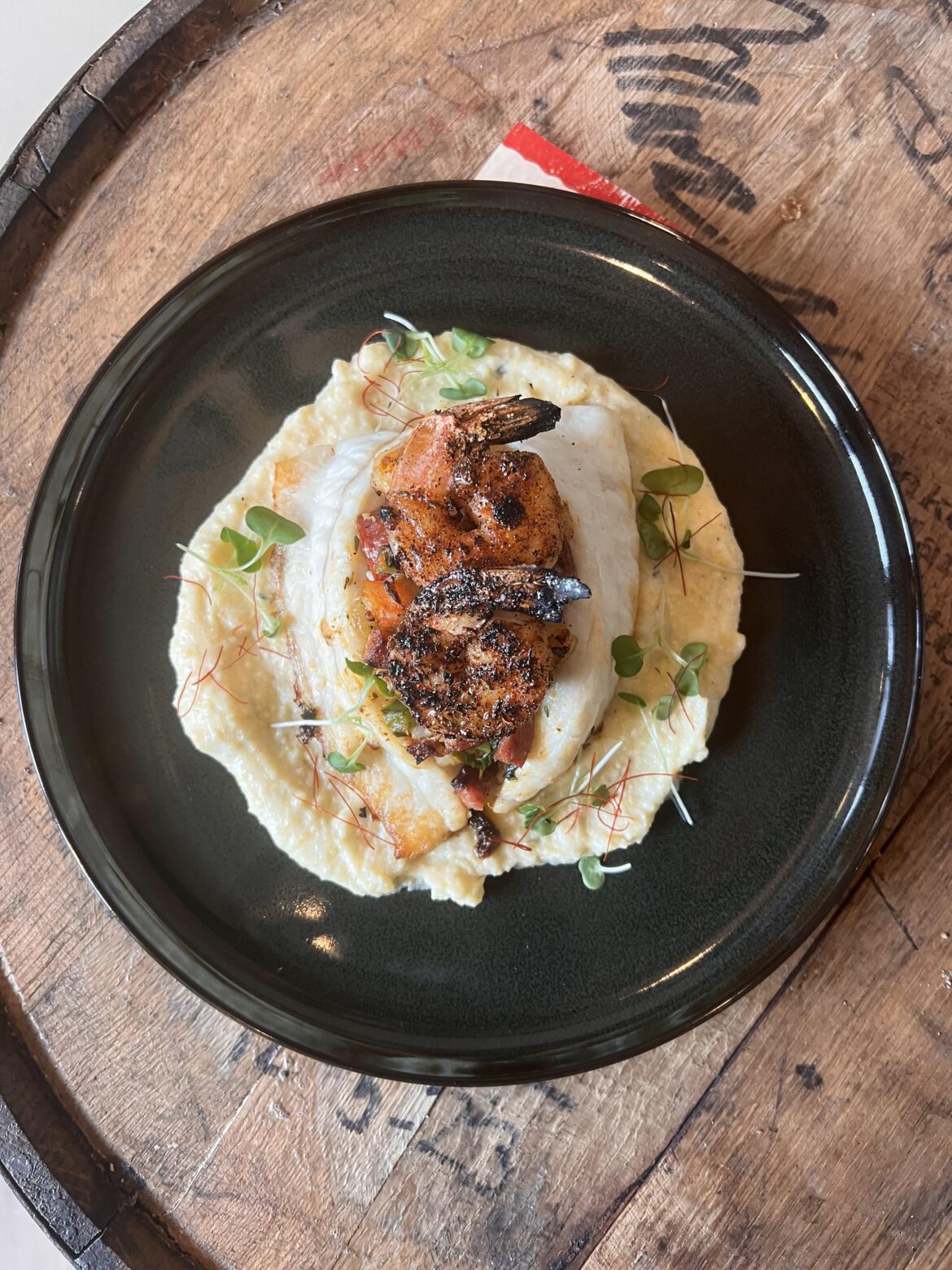 Cajun Stuffed flounder w/ andouille sausage,bell peppers and grilled blackened 16/20 shrimp over a cornmeal porridge.