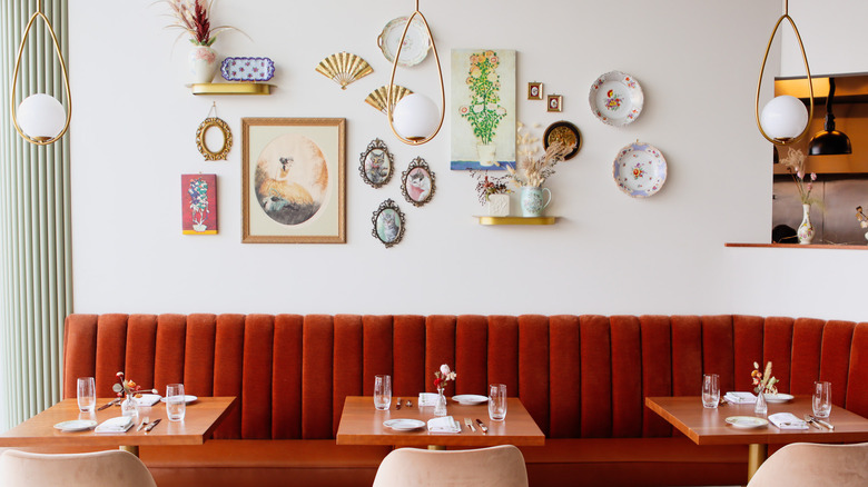 Noisette's antique-chic interior, featuring a burnt orange booth and delicate wall art