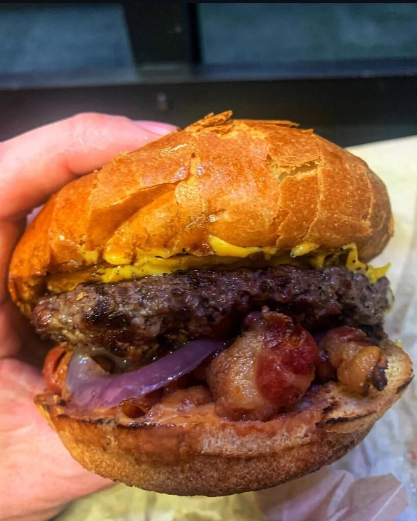 Cheeseburger with bacon, onion ring and grilled onions at Uncle Boys in San Francisco, Ca. This is a small hole in the wall type spot.