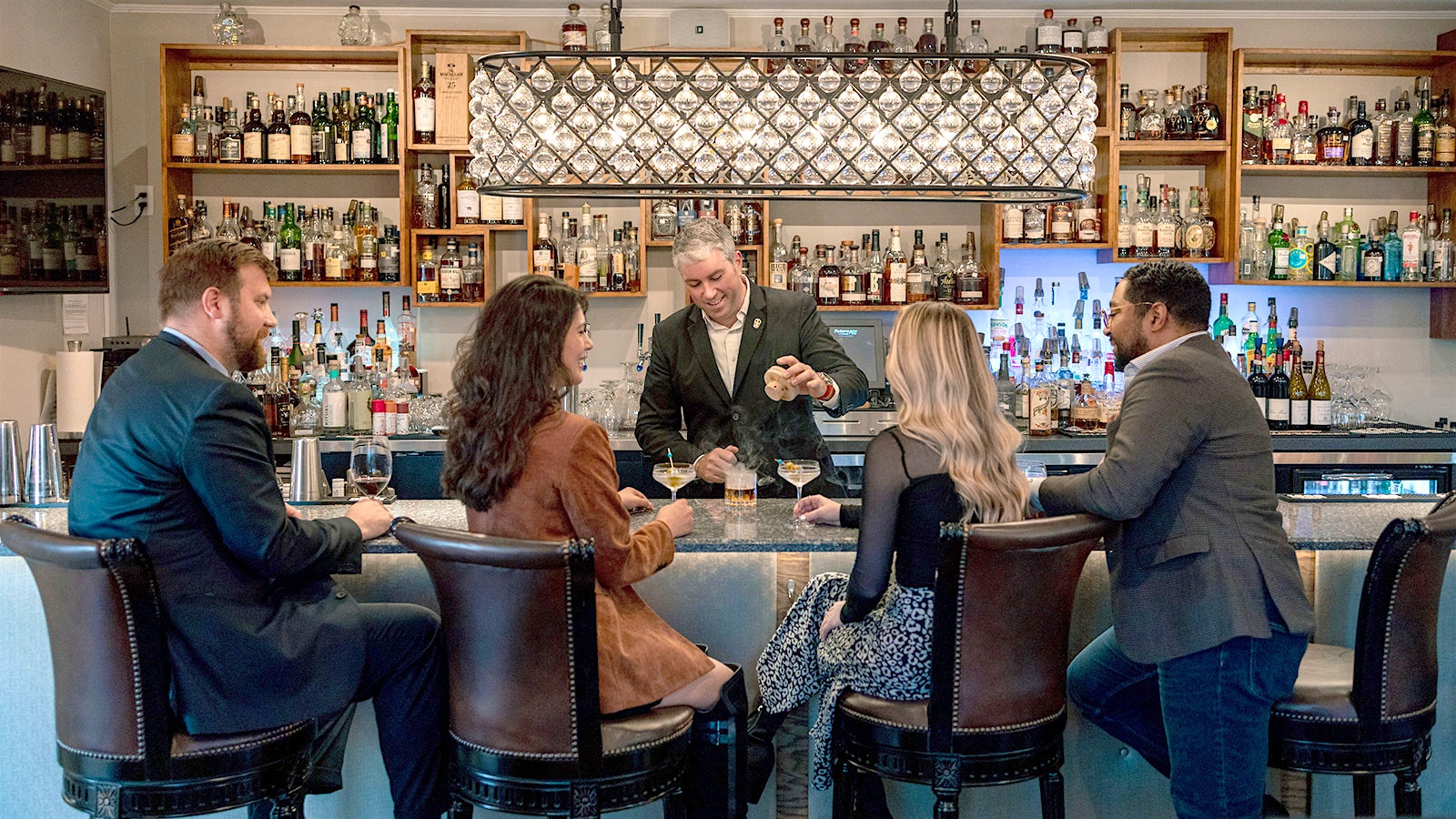Diners enjoying wine and cocktails at the bar at L'Auberge Provençale