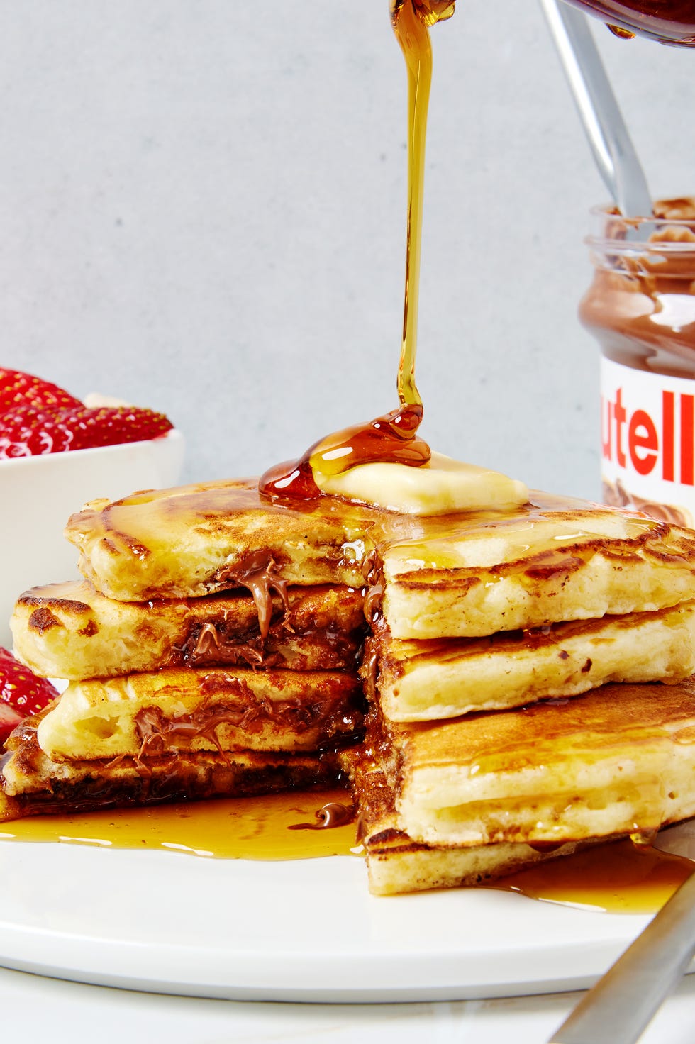 three pancakes stuffed with nutella and topped with butter and syrup