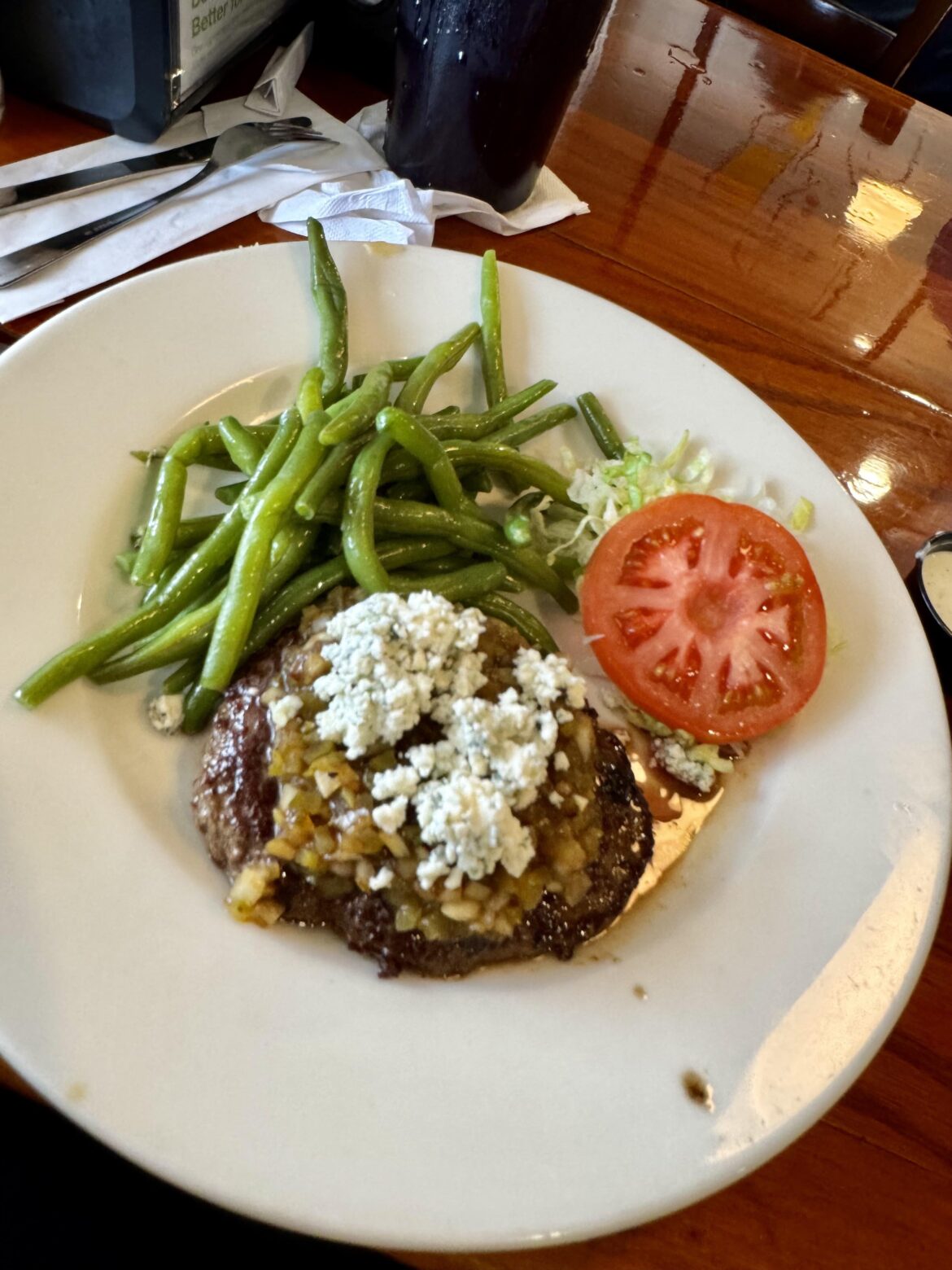 A1A Steakhouse Burger from Sunset Grille in St. Augustine FL: topped with grilled vidalia onion, steak sauce pickle relish, crumbled blue cheese, lettuce and tomato.