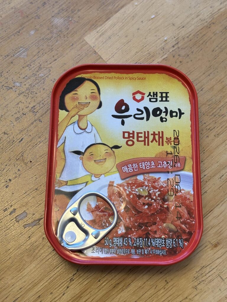 Sempio brand Braised Dried Pollock in Spicy Sauce Banchan, cooked with Rice and Vegetables, then topped with Preserved Pickled Mustard and an Over-Medium Egg