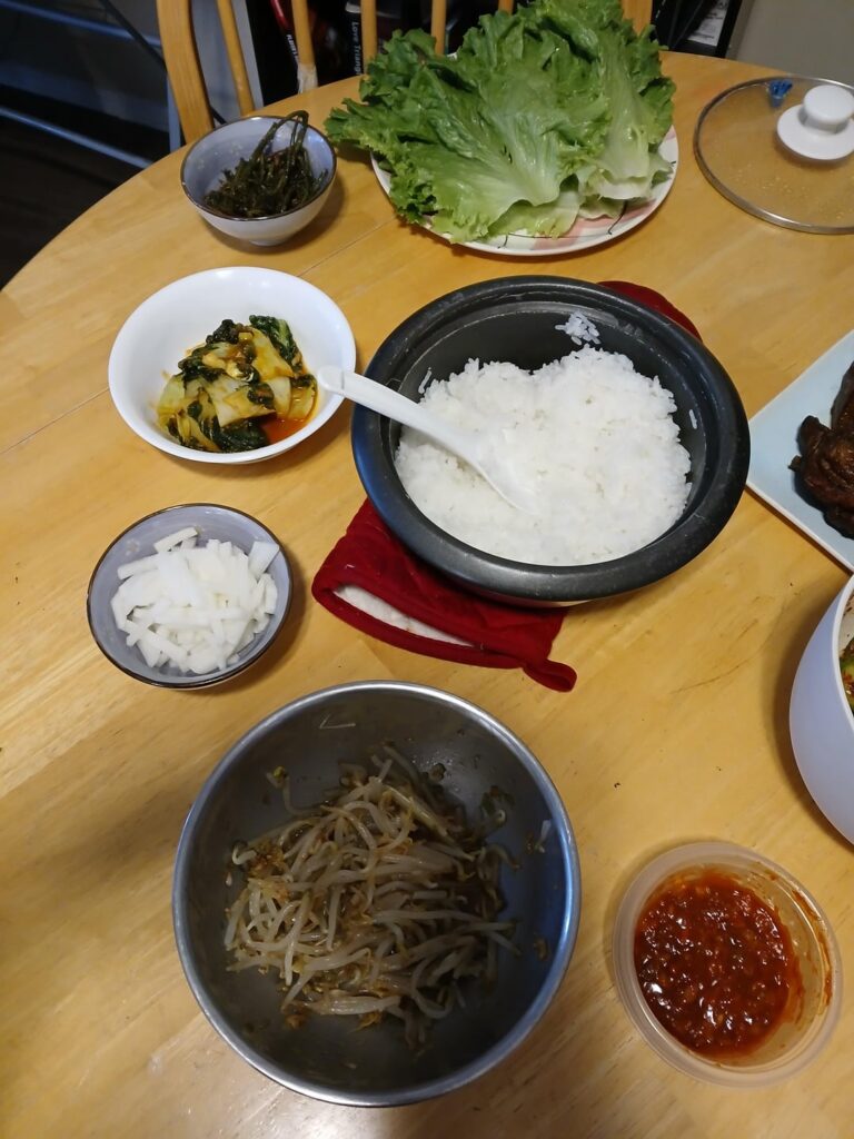 Lettuce ssam with dong po rou, braised bokchoy, carrot top namul, beansprout namul, cucumber sanchangee, sweet and sour daikon, kimchi, and a gochugang sauce.