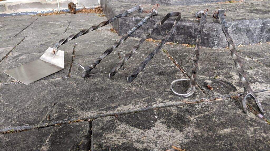 As a followup post to my other one about grilling related goodies I make in my home blacksmith shop, check out a project completed last summer: A full BBQ set made from railroad spikes, old railing, and other scrap! Fork, Tongs, Left and Right-handed meat flippers, and a stainless spatula.