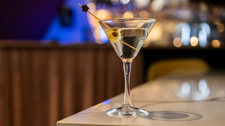 martini with olive on bar table