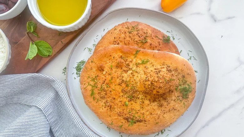 Plate with seasoned homemade flatbreads next to dipping oils