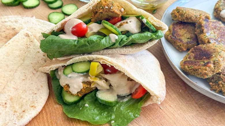 Pitas filled with falafel, salad, and tahini