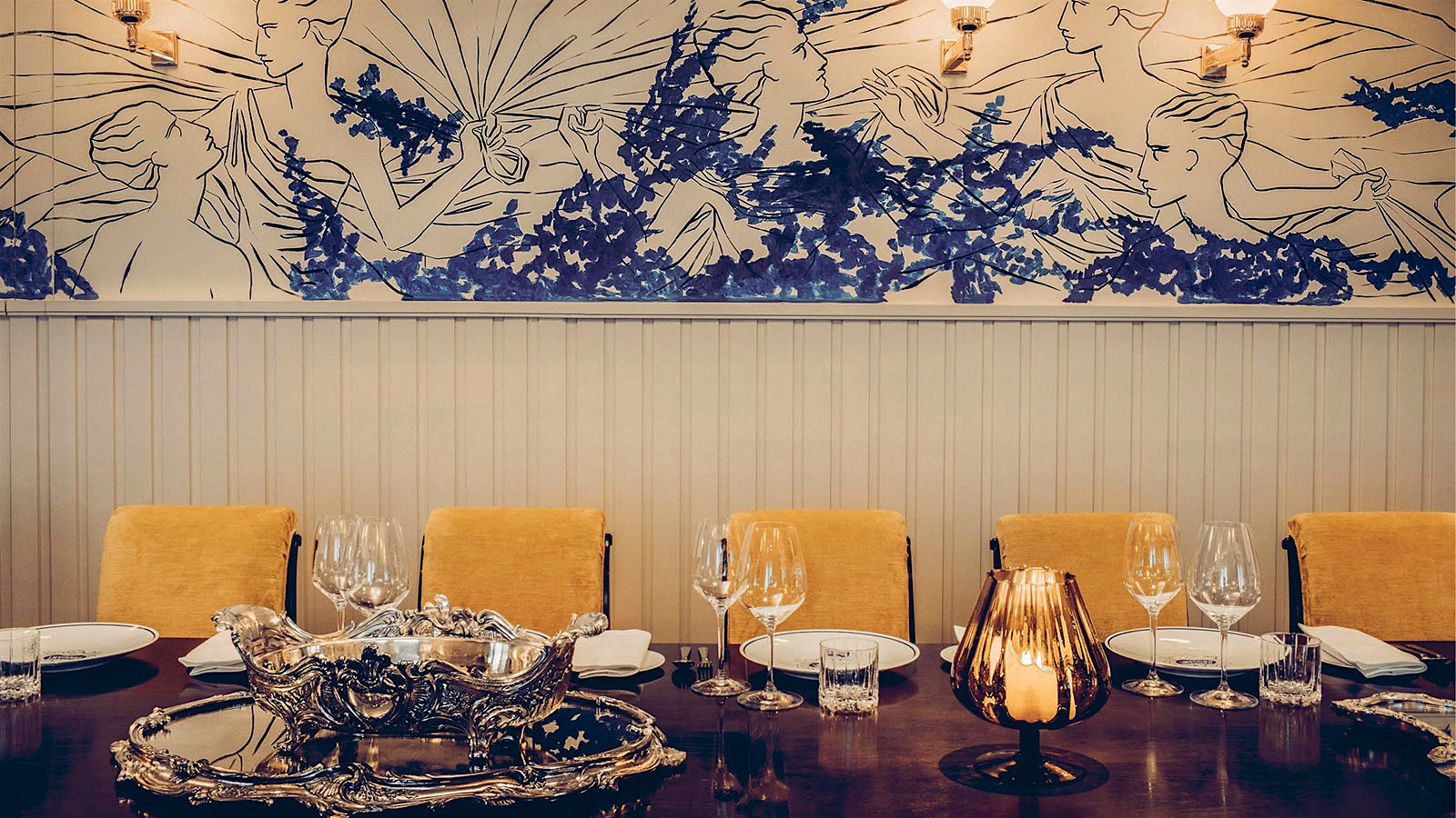 A dining table next to a Greek-inspired fresco at Drouant in Paris