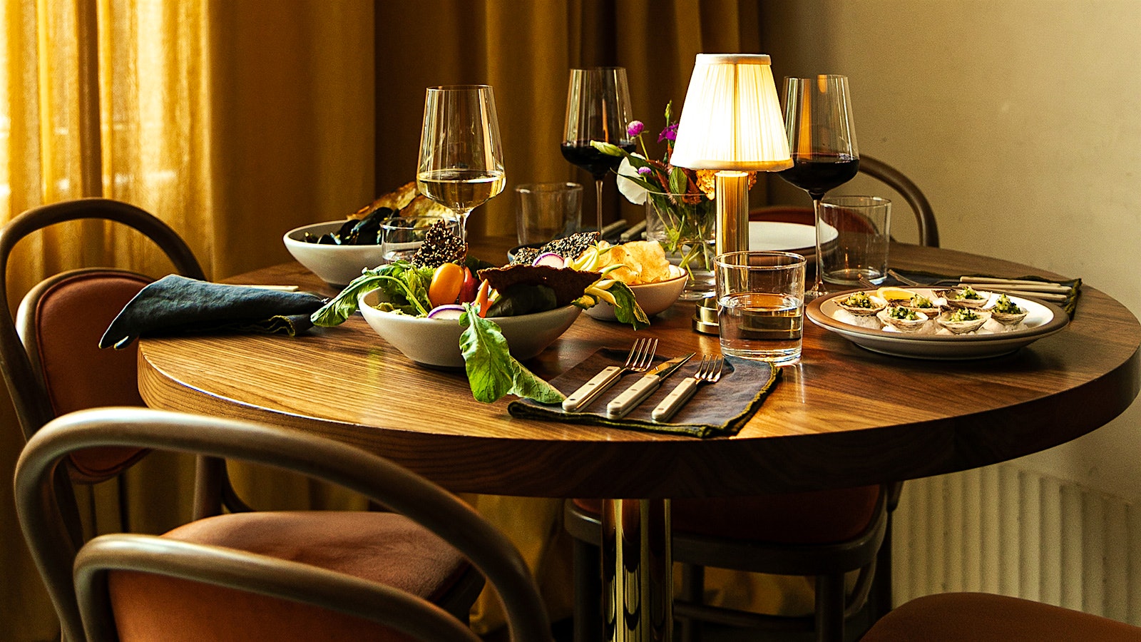 A wood table set with oysters and other dishes at Le Bon Nosh