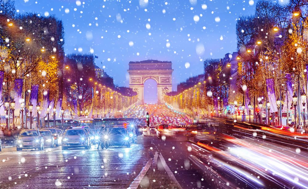 Arch de Triomphe and the Champs Elysees in Paris on a Christmas snowy night, France