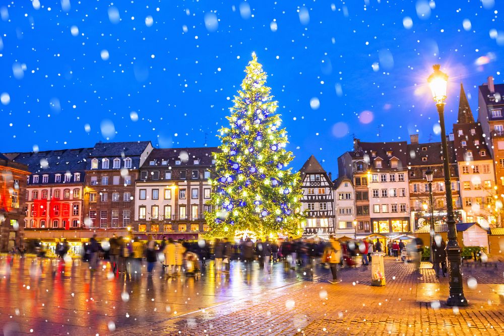 Christmas tree and xmas market at Kleber Square at night in the medieval city of Strasbourg, aka the capital of Noel, Alsace, France