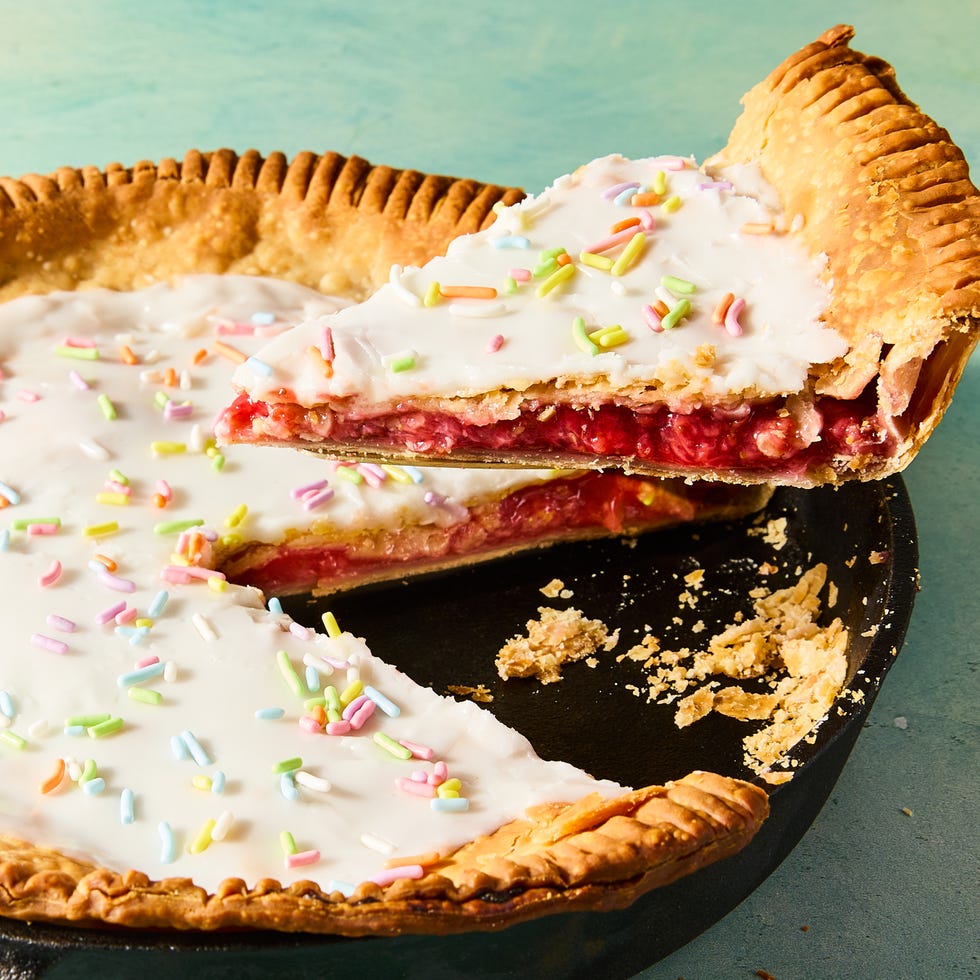 flaky pastry in a pie dish filled with strawberry filling and topped with icing and sprinkles