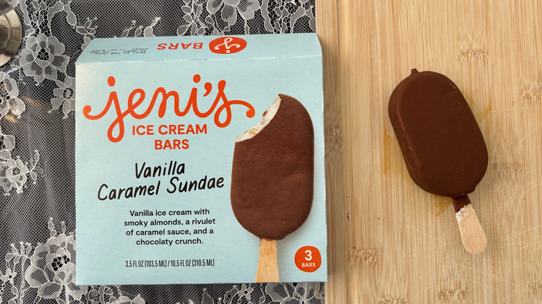 Box Jeni's Vanilla Caramel Sundae ice cream bars and unwrapped bar on cutting board next to it