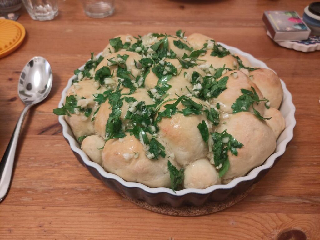 Пампушки / Pampushky — Ukrainian yeast buns, spread with garlic and parsley; served as a side to borshch (борщ)