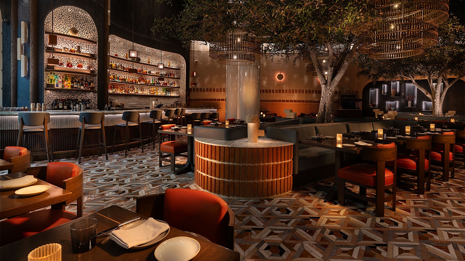  The interior of Orla by Michael Mina, with dark blue walls, warm lighting, and greenery