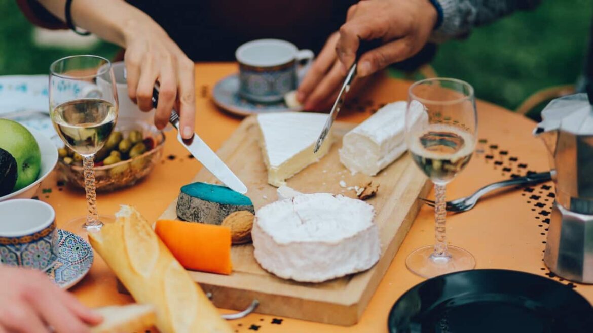 Can you eat cheese and drink red wine to improve your health? Friends dining in the suburban garden of Paris drinking wine and eating cheese