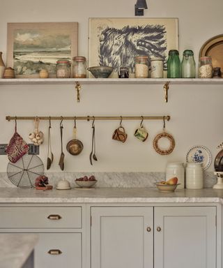 A grey kitchen with brass hardware