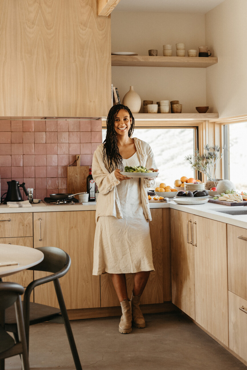 Woman serving salad in kitchen.