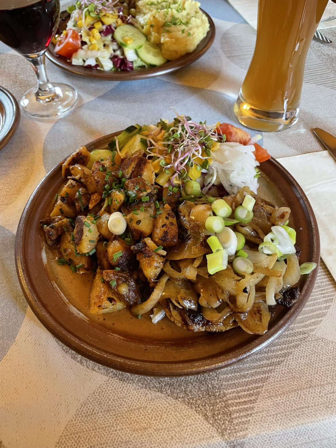 Rostbrätl (roast pork) with onions, potatoes, and side salad
