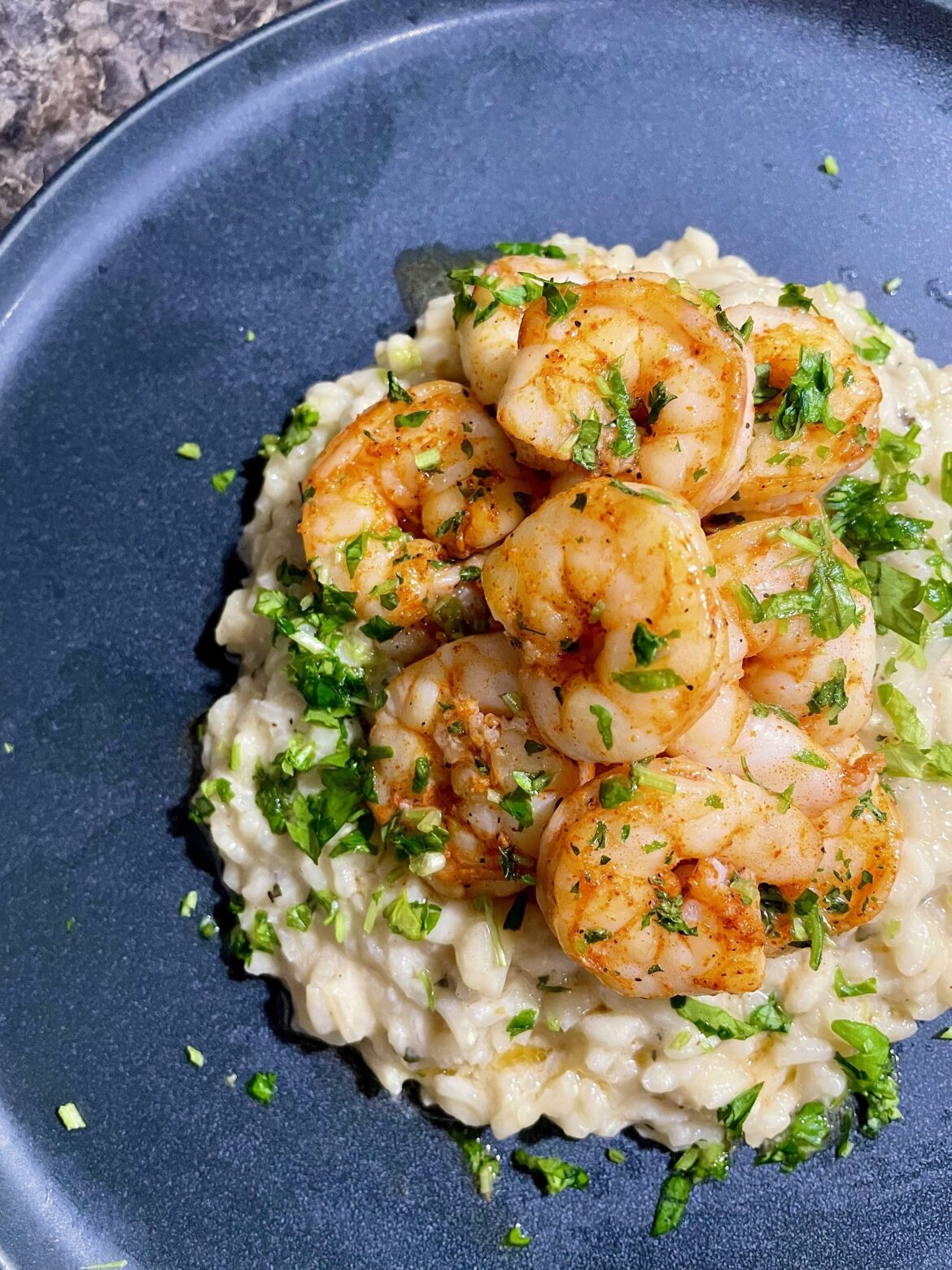 [OC] Cajun broiled shrimp and herb risotto. Garnished with chopped parsley.