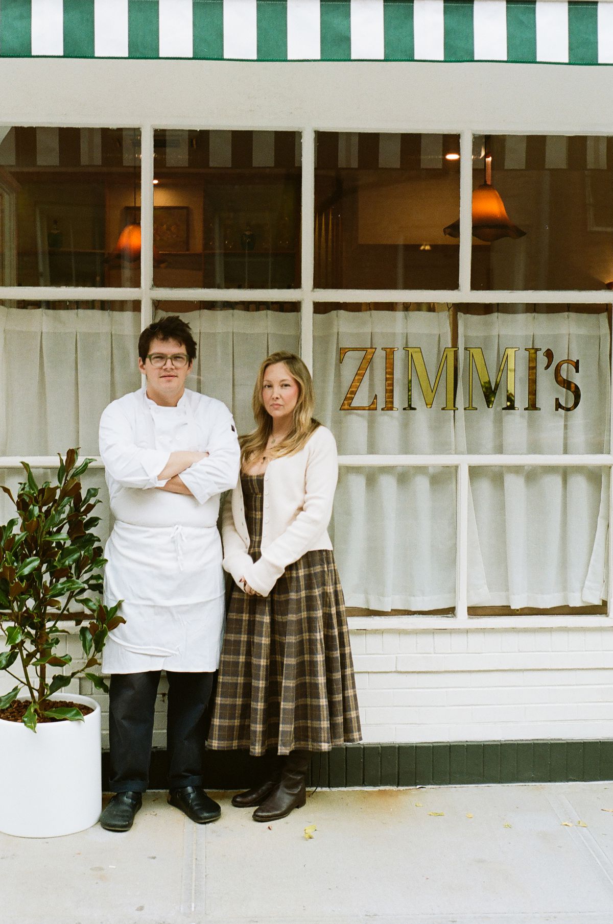 Two restaurant owners outside their restaurant.